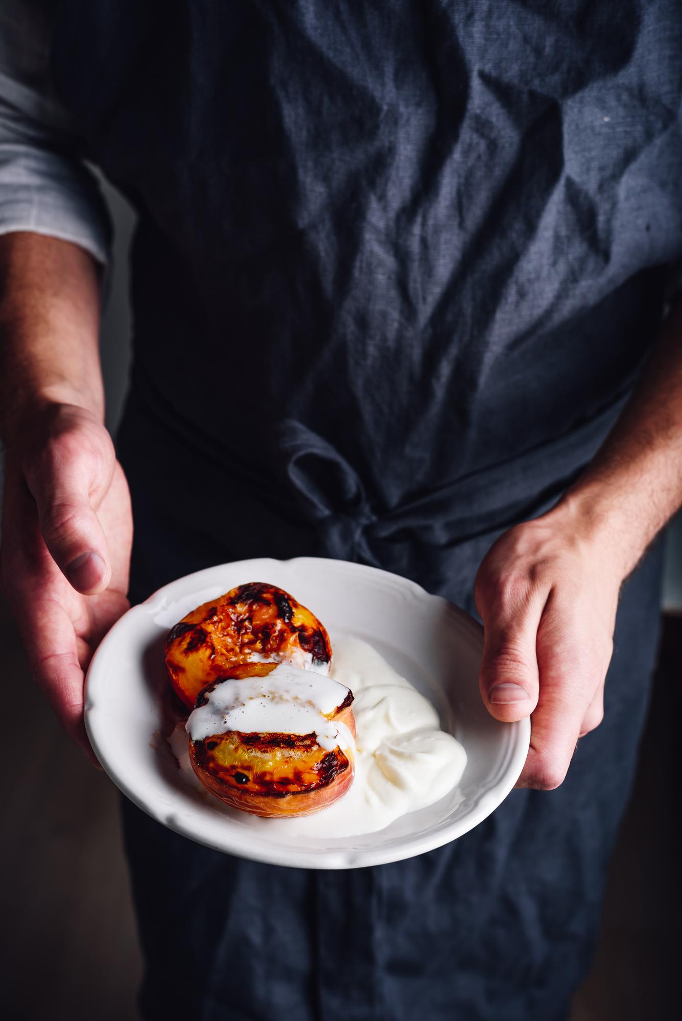 Chef shaping plated dish in warm studio